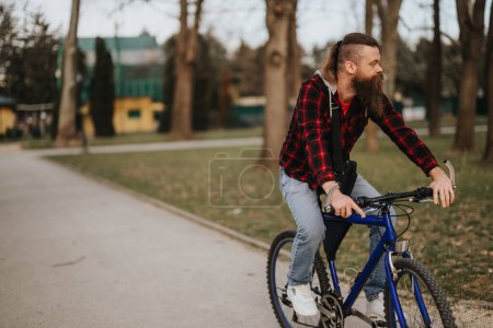 Un hombre barbudo vistiendo una camisa a cuadros está caminando tranquilamente por un parque sereno, encarnando la relajación y un estilo de vida saludable..