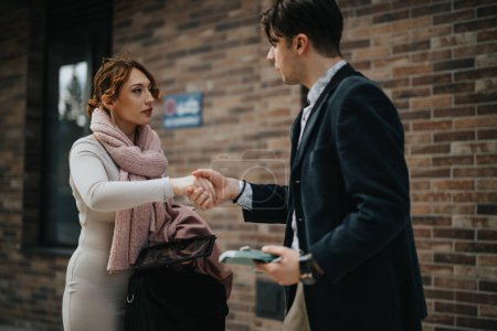 Two business associates greet each other with a handshake outside a modern office building