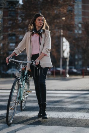 Joven confiada con su bicicleta cruzando la calle en un entorno urbano, disfrutando de un día soleado al aire libre.