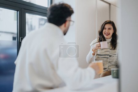 Cheerful businesspeople enjoying morning coffee, brainstorming ideas and discussing collaboration in a modern office kitchen. Positive atmosphere and teamwork.