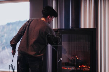A person tending to a wood-burning stove, creating a warm and inviting atmosphere for a friendly gathering at home.