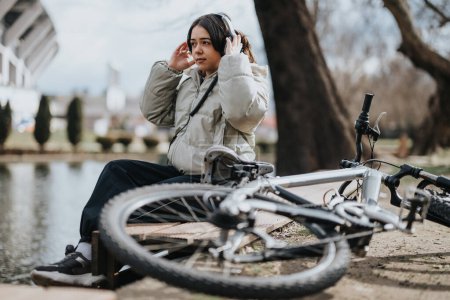 Ein angenehmer Tag im Park: Ein junges Mädchen entspannt sich neben ihrem Fahrrad und saugt die friedliche Atmosphäre auf.
