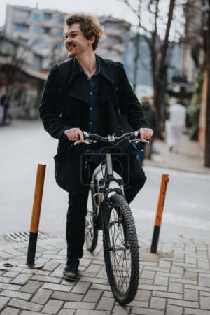 Un homme d'affaires joyeux en tenue décontractée se tient debout avec son vélo sur un trottoir urbain, exposant un mode de transport durable dans la ville.
