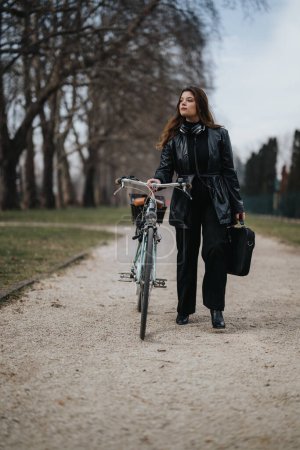 Stylish businesswoman strolling with her bicycle in a city park, depicting a blend of modern lifestyle and eco-friendly transportation.