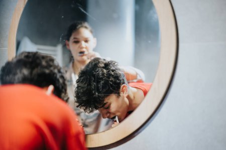 Un jeune adulte se toilettant attentivement devant un miroir circulaire, capturant les pratiques quotidiennes d'hygiène.