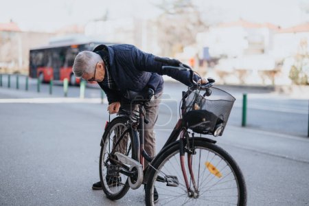 An elderly man is securing his bicycle with a lock outdoors, showcasing active senior lifestyle and urban commuting.