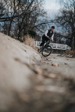 A young male teenager is pictured cycling on a path in the park, displaying a sense of freedom and activity.
