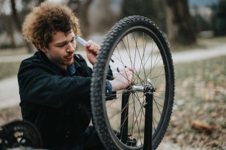 Un joven empresario arregla su bicicleta en un parque, combinando negocios y un estilo de vida saludable.