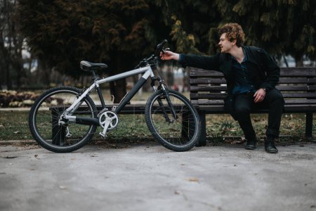 Un joven emprendedor profesional disfruta de un descanso en un parque de la ciudad con su bicicleta, mostrando un enfoque moderno para el trabajo y el equilibrio de la vida.
