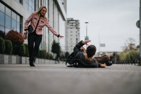 Eine mitfühlende Geschäftsfrau reicht einem Mann, der auf einem städtischen Bürgersteig gestürzt ist, die helfende Hand.