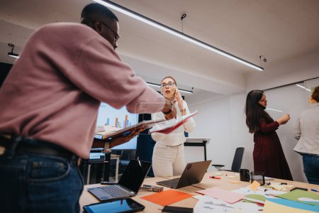 Eine multiethnische Gruppe von Fachleuten arbeitet drinnen zusammen, diskutiert Business Analytics und fördert Kreativität für erfolgreiche Teamarbeit.