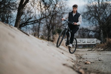 Ein junger männlicher Teenager fährt mit seinem Mountainbike auf einem Feldweg und genießt die Freiheit der Outdoor-Aktivitäten.