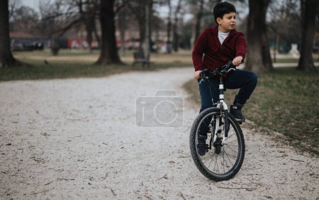 Ein fröhlicher kleiner Junge, der im Park mit dem Fahrrad unterwegs ist und Aktivität und kindliche Freude beschreibt.