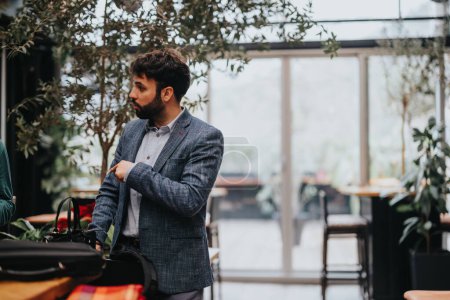 Konzentrierter junger Mann justiert seine Jacke, während er sich auf ein Startup-Business-Gespräch in einem modernen urbanen Café-Setting vorbereitet.