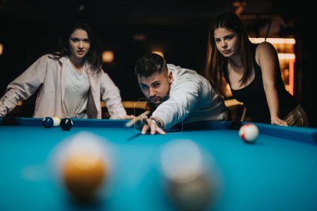 Eine Gruppe von Freunden vergnügt sich bei einem lässigen Billardspiel in einer örtlichen Poolhalle und zeigt Freizeit und Geselligkeit.