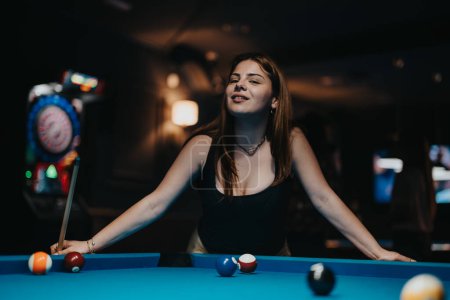 Une jeune femme concentrée jouit d'un jeu de piscine dans un bar confortable et faiblement éclairé, mettant en valeur la vie nocturne et les activités de loisirs.