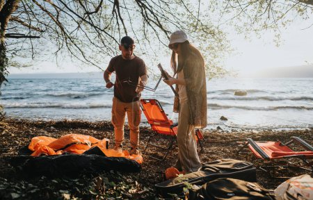 Two friends enjoy setting up their camping gear by a scenic lakeside, embracing the joy and relaxation of outdoor life.