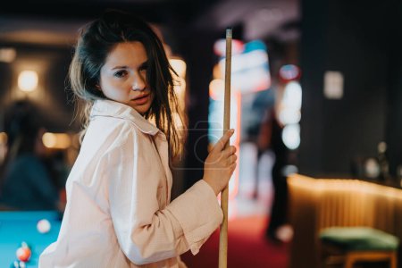 Una joven disfrutando de un juego de billar con amigos en un bar acogedor, que encarna la felicidad y la convivencia.