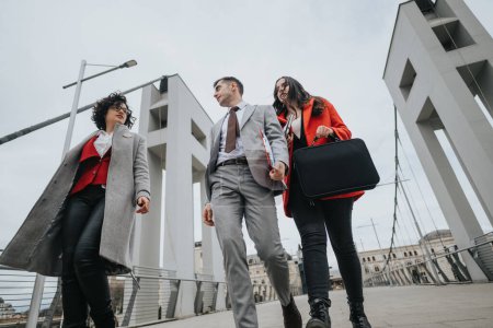 Tiefansicht von Geschäftskollegen in stylischer Kleidung, die im Freien spazieren gehen, mit der Stadtarchitektur im Hintergrund.