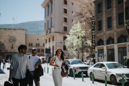 Grupo de profesionales de negocios que participan en una discusión mientras caminan por una calle de la ciudad, retratando el trabajo en equipo y la colaboración.