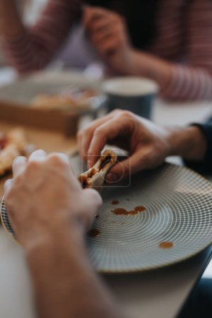 A close-up image capturing the essence of dining together, with a focus on hands and a half-eaten sandwich, highlighting casual eating.