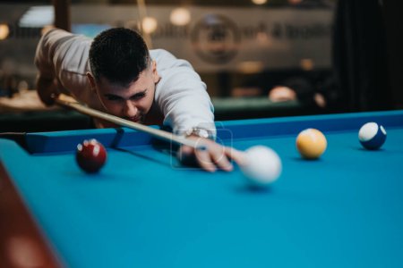 Joyful leisure time as a focused young man plays pool, demonstrating skill and precision in a friendly game.
