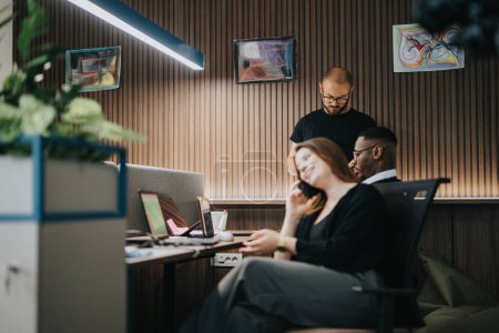 Drei Fachleute in einem modernen Büroumfeld führten eine Projektdiskussion durch. Ein konzentriertes und produktives Team, das effizient an Geschäftslösungen arbeitet.