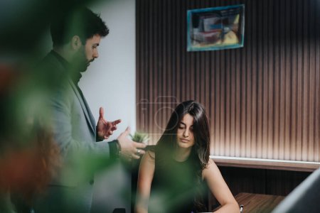 In a modern office, a focused female employee listens intently as her male manager explains project tasks. The setting reflects a professional discussion aimed at problem-solving.