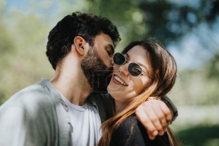 A carefree young couple enjoys a casual, joyful moment, embracing each other in an urban park on a sunny day, radiating happiness and positivity.