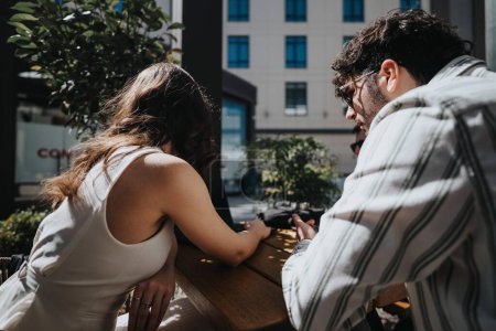 Professional man and woman having a discussion at an outdoor cafe in an urban setting.