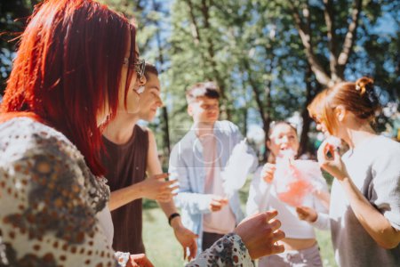 Eine Gruppe fröhlicher Freunde genießt flauschige Zuckerwatte in einem Park und erlebt Spaß und Lachen an einem sonnigen Tag.