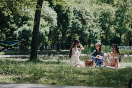 Capturando un momento alegre, tres amigos se relajan durante un día soleado en el parque, conversando y disfrutando de un picnic..