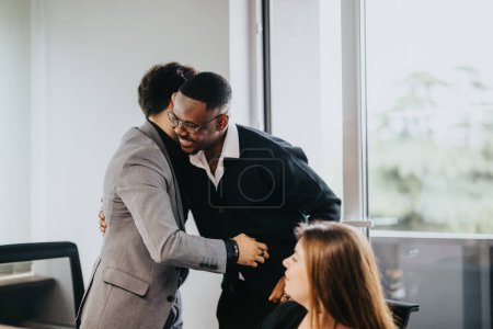 Dos colegas de negocios masculinos se abrazan en una oficina bien iluminada, mostrando apoyo y camaradería. Una compañera de trabajo observa, contribuyendo a la cultura de trabajo acogedora e inclusiva representada.