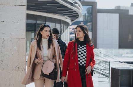 Fashionable friends walking in urban setting wearing stylish winter clothes.