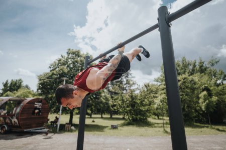 An athletic man engages in intense calisthenics, executing a horizontal hold on a bar in a sunny urban park, demonstrating strength and fitness.