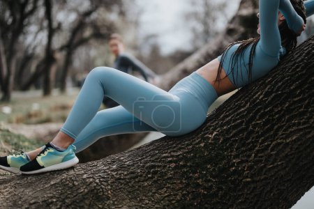 Fitness-Enthusiast macht Pause, lehnt sich an einen Baum und zeigt Engagement für einen aktiven Lebensstil im Freien.