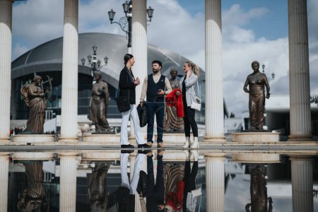 Drei junge Unternehmer diskutieren im Freien, mit klassischen Statuen und Säulen im Hintergrund.