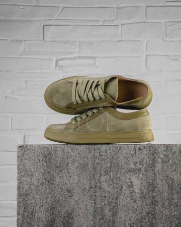 Foto de Zapatos de calle modernos de pie piedra sobre piedra sobre un fondo gris - Imagen libre de derechos