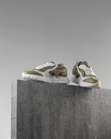 Téléchargez les photos : Chaussures de rue modernes debout pierre sur pierre sur un fond gris - en image libre de droit