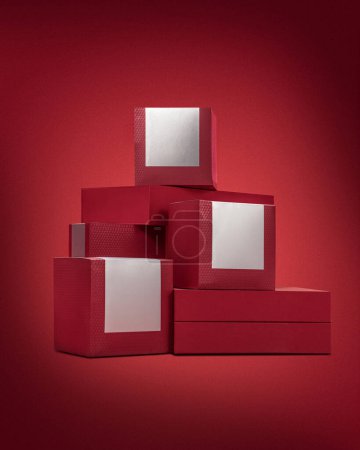 Téléchargez les photos : Boîtes rouges avec étiquettes de produits vierges sur fond rouge - en image libre de droit