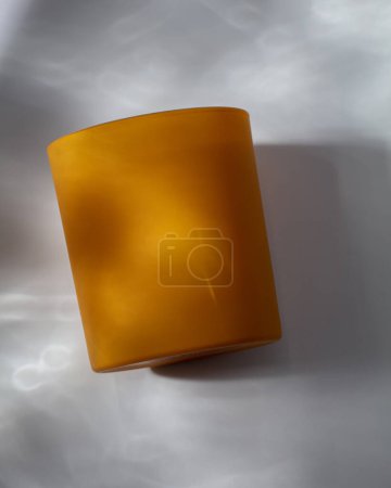 Foto de Vela amarilla sobre fondo blanco con sombras de agua - Imagen libre de derechos