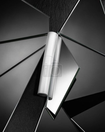 Foto de Embalaje de rímel cosmético sobre un fondo de piezas de plumas espejadas en piedra de textura negra - Imagen libre de derechos