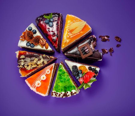 Téléchargez les photos : Affichage artistique ludique de tranches de gâteau au design unique façonnées en carrousel sur fond violet festif. Concept de plaisir et de créativité de l'art des confiseries douces - en image libre de droit