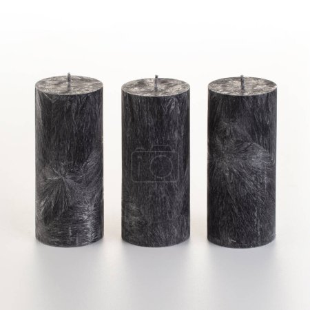 Photo for Set of four black palm wax candles with unique ice-like patterns arranged on white background. Concept of stylish handcrafted accessories adding modern touch to home or office decor - Royalty Free Image