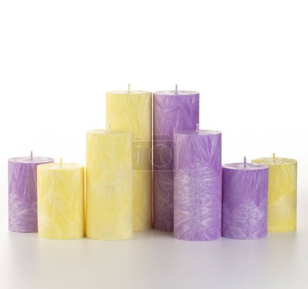 Exquisite Kollektion aromatischer gelber und lila Palmwachskerzen mit einzigartiger Eiszapftextur, die dem Raum Farbe und entspannenden Duft verleihen, auf Weiß. Handgefertigte Accessoires