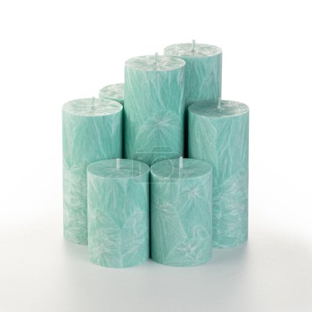 Natural green palm wax pillar candles of varying heights; featuring unique ice pattern texture grouped on white background. Handmade accessories for refreshing interior decor