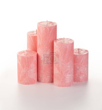 Photo for Natural pink palm wax pillar candles of varying heights; featuring unique ice pattern texture grouped on white background. Handmade accessories for refreshing interior decor - Royalty Free Image