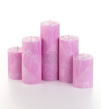 Natural pirple palm wax pillar candles of varying heights; featuring unique ice pattern texture grouped on white background. Handmade accessories for refreshing interior decor