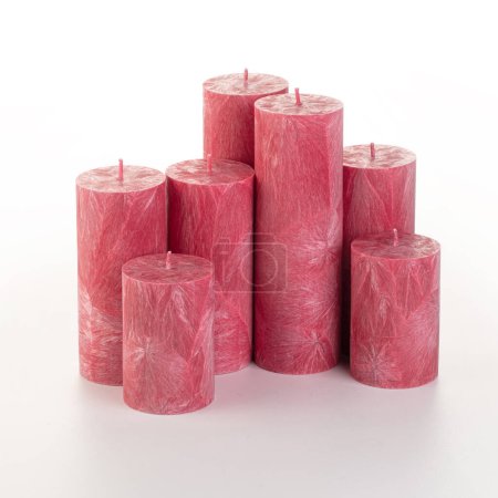 Natürliche Kerzen aus rotem Palmenwachs unterschiedlicher Höhe mit einzigartiger Eisstruktur, gruppiert auf weißem Hintergrund. Handgemachtes Zubehör für erfrischende Inneneinrichtung
