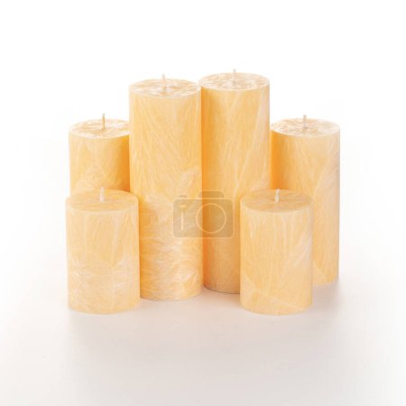 Photo for Natural orange palm wax pillar candles of varying heights; featuring unique ice pattern texture grouped on white background. Handmade accessories for refreshing interior decor - Royalty Free Image